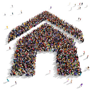 Large group of people gathered together in the shape of a house symbol