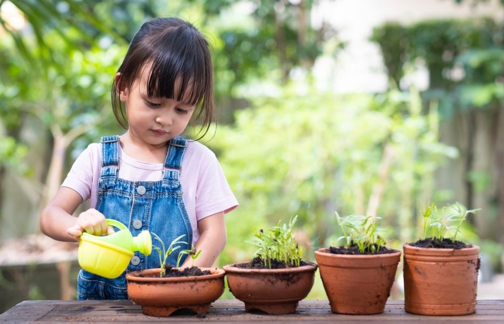 young girl watering plants