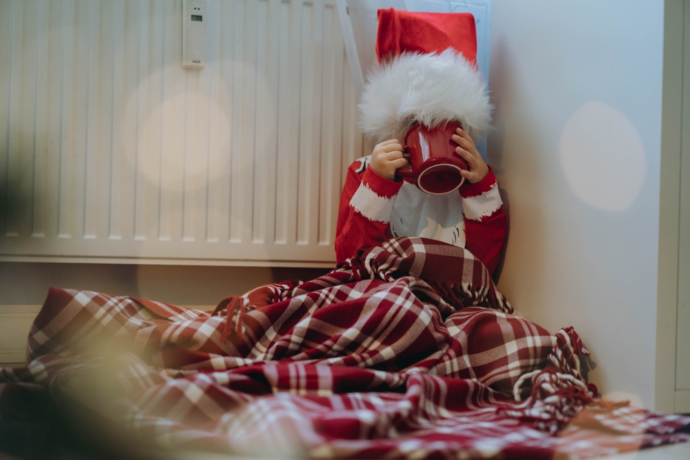 Christmas boy sitting by radiator