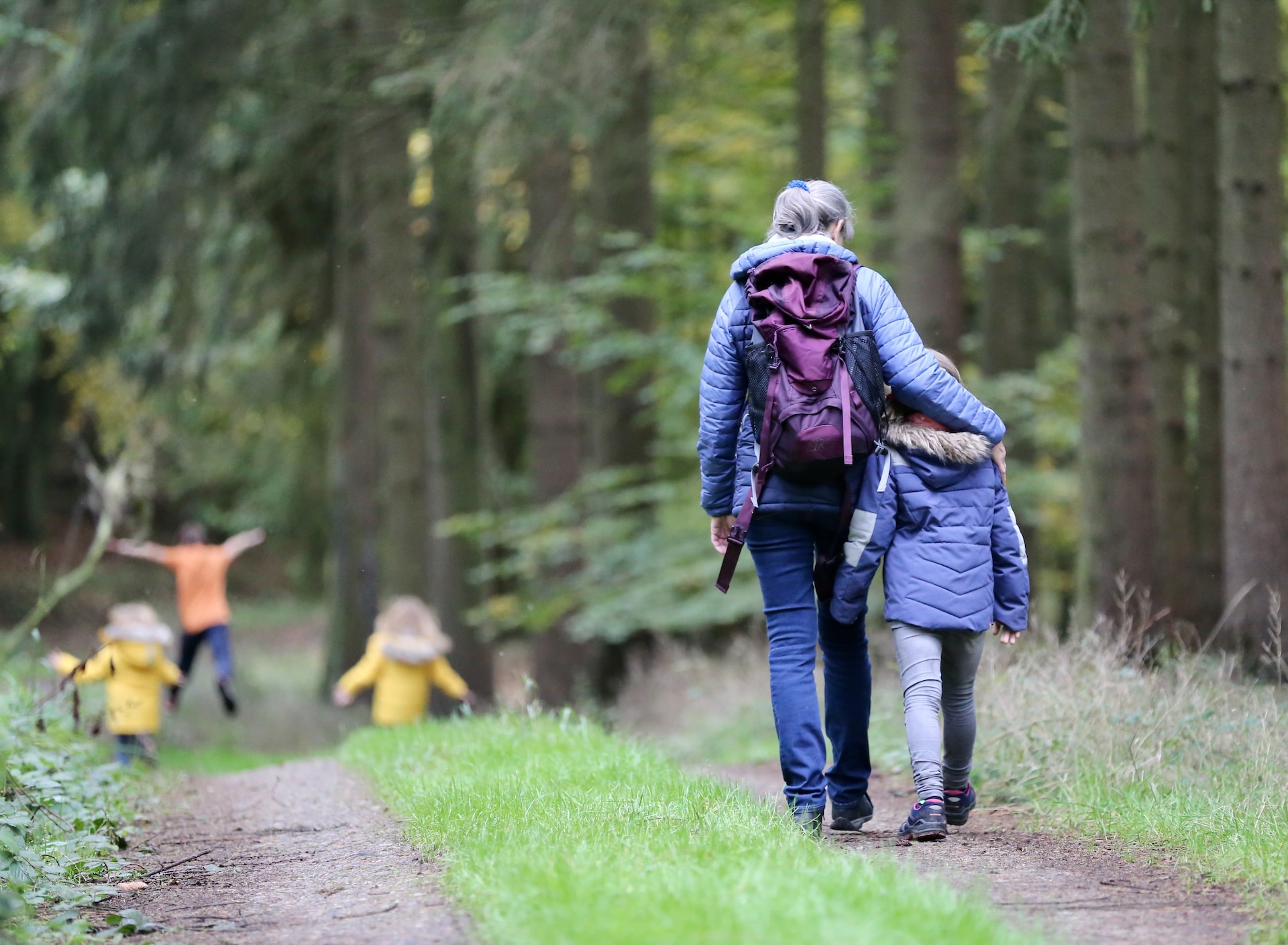 mother and son enjoying a walk with kids running in the distance